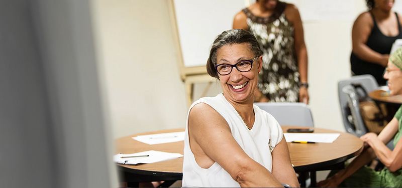 photo of a woman smiling at a community meeting